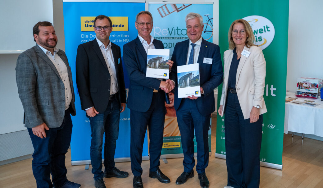 Auf dem Bild sind zu sehen Lorenz Wachter, Johannes Offenthaler, Roland Wohlmuth, Anton Kasser und Elisabeth Punesch. Roland Wohlmuth und Anton Kasser geben sich per Handschlag die Hand und halten jeweils den ReVital Kooperationsvertrag in den Händen.